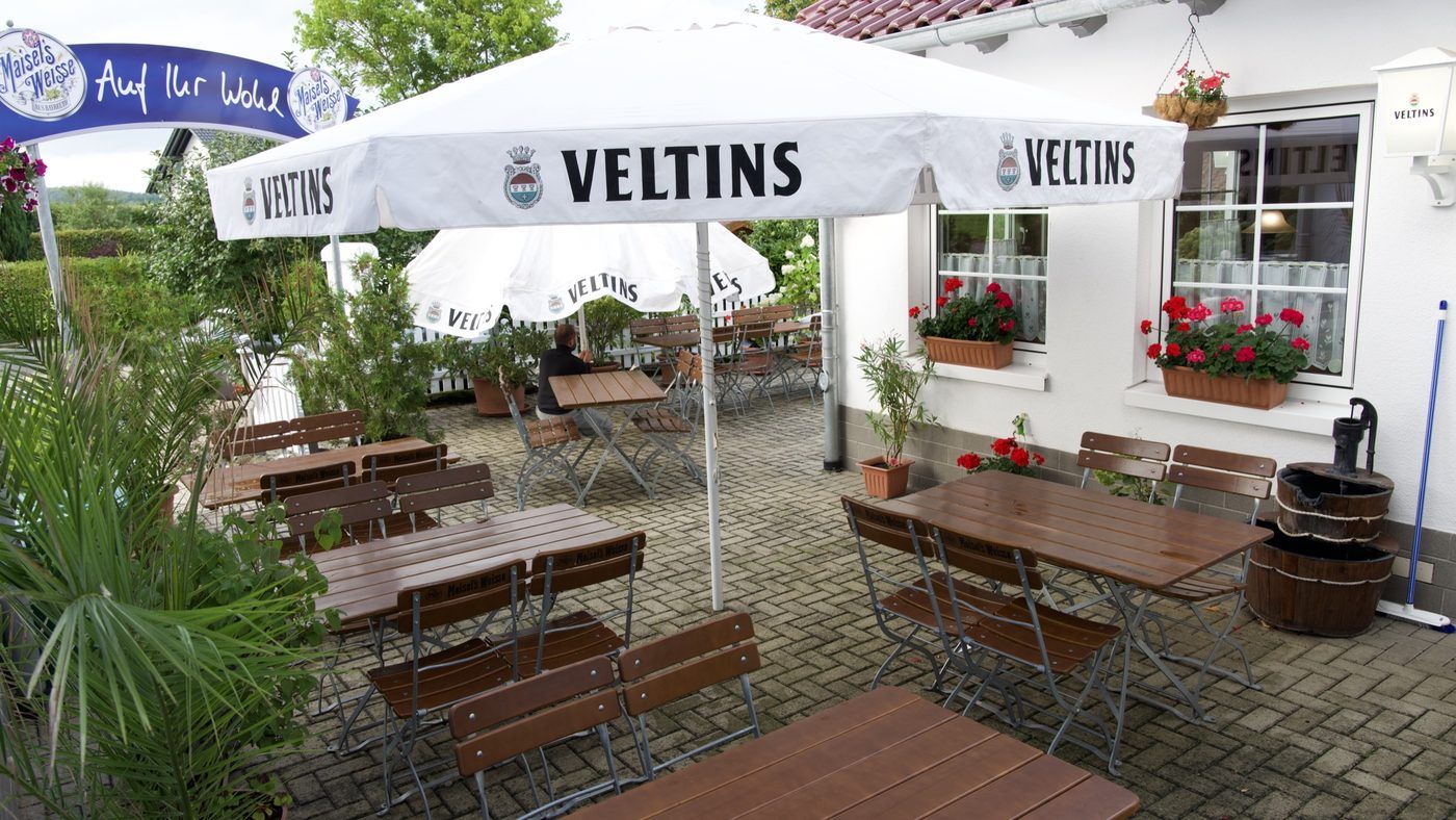 Biergarten mit Sonnenschirmen und Bierbänken