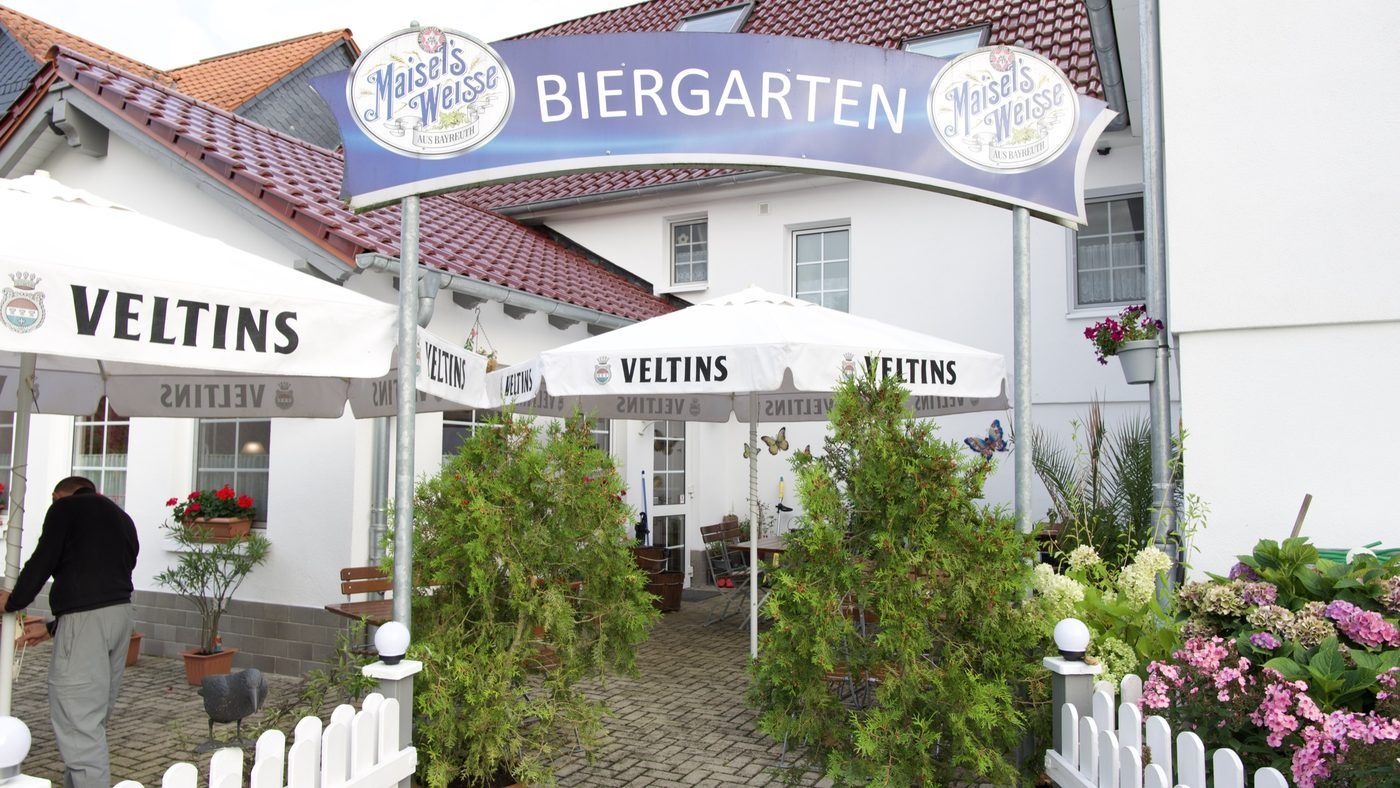 Schirm mit der Aufschrift Biergarten vor dem Haus