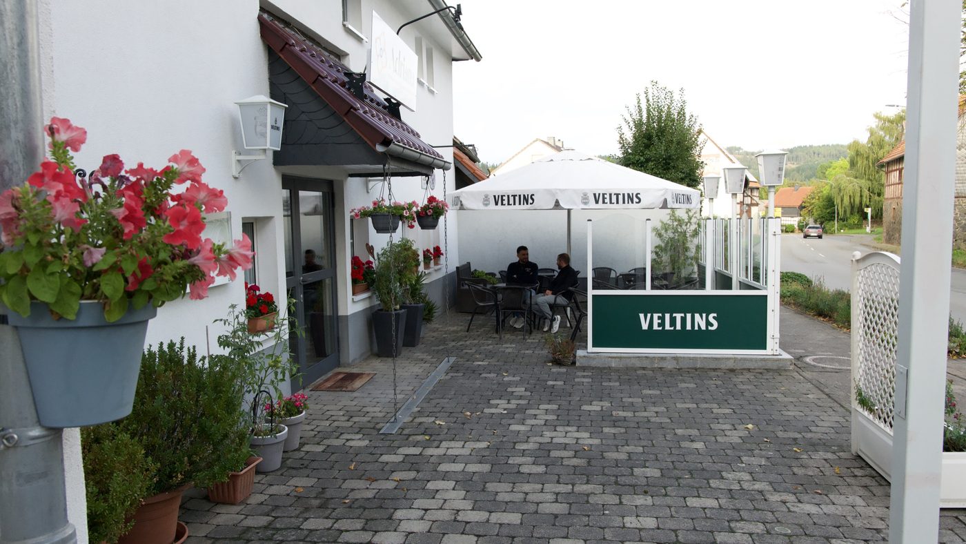 Der Weg in den Biergarten, mit Geranien und Schirmen