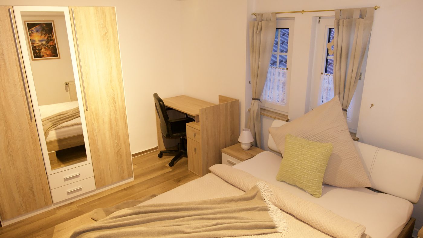 Einzelzimmer Nr. 7 mit Dreiviertelbett, Schreibtisch und zwei Fenstern